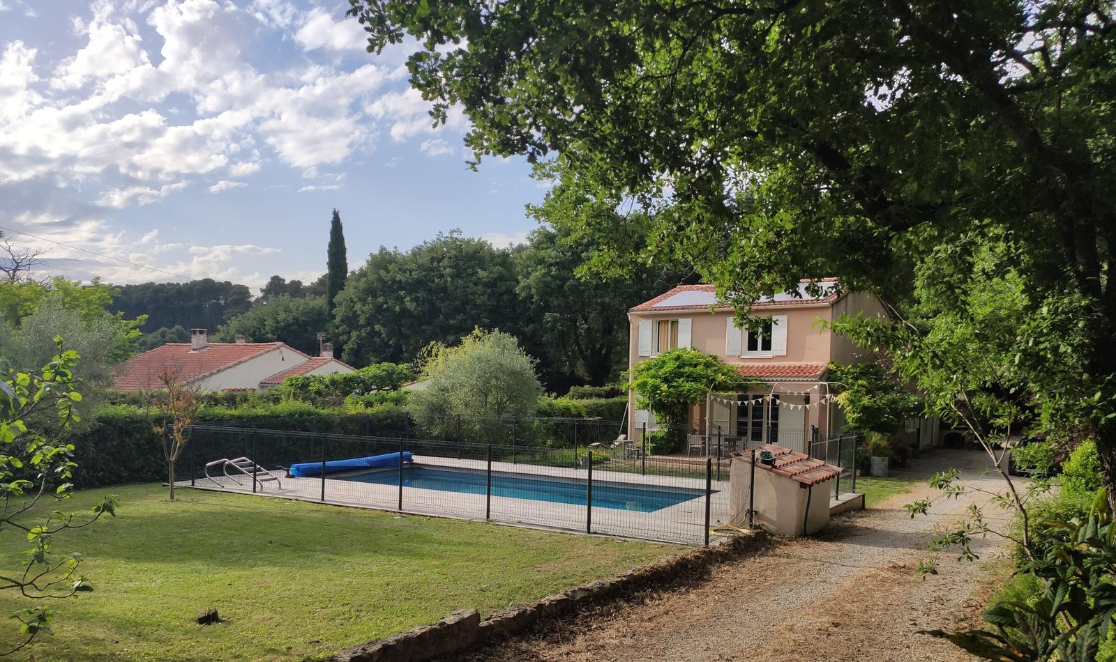 La villa, sa piscine et son jardin en fin de journée